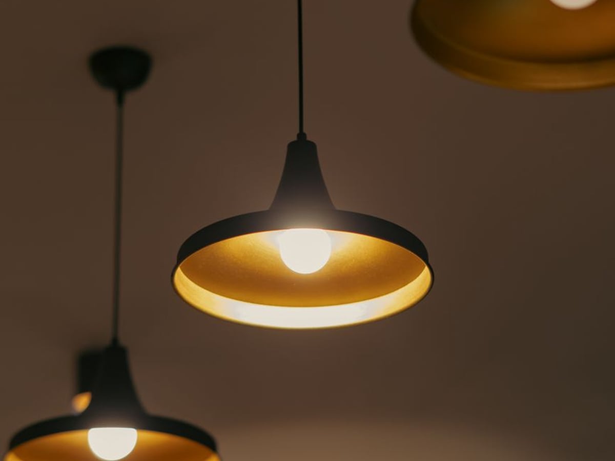 Séjour éclairé le soir par des luminaires suspendus à lumière chaude
