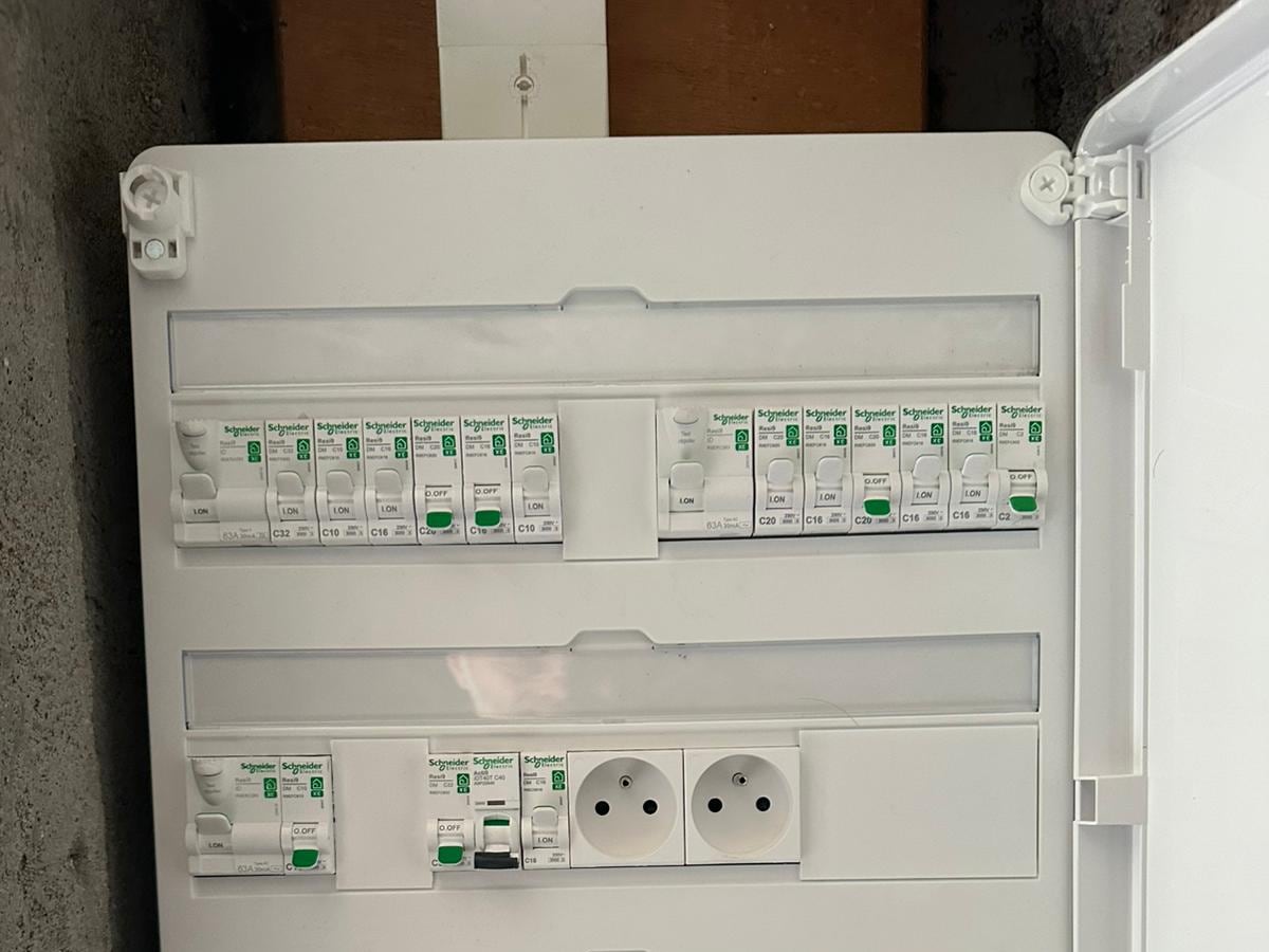 Cuisine équipée de spots encastrés et d'un bandeau LED chaud sous les meubles