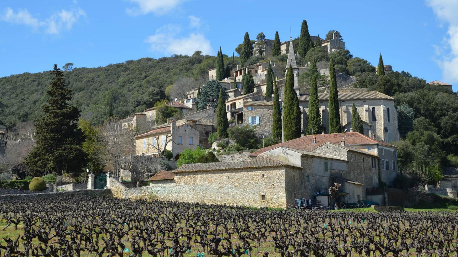Village de pierre perché entouré de vignes et de garrigue dans le Gard
